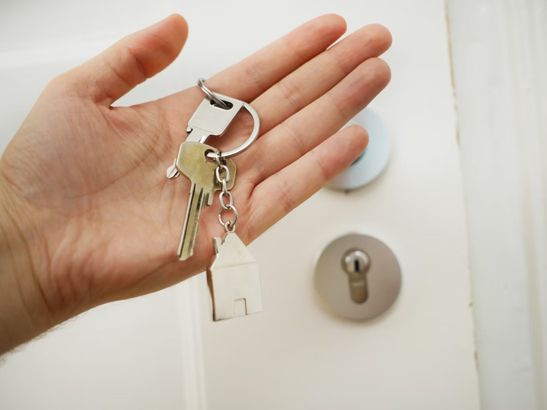 A person holding keys for a door in their hand