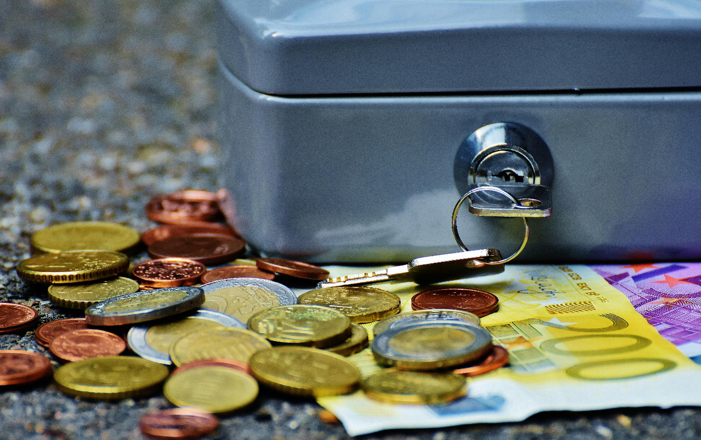 banknotes and coins beside a safe