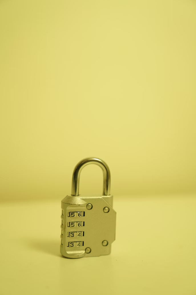 Close-up of a padlock placed on a yellow surface
