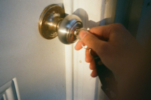 A person unlocking a door with a key
